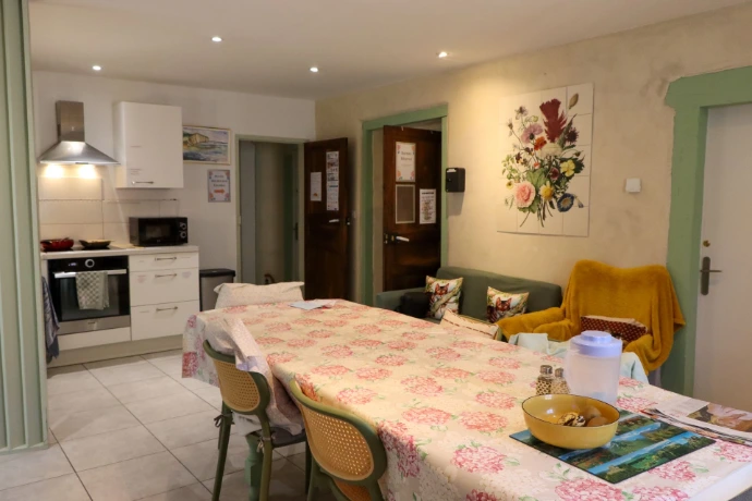 Vue sur la cuisine ouverte et la salle à manger de la Maison Chaumet, avec une décoration chaleureuse.