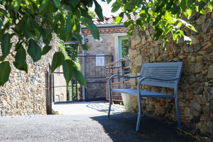 Espace extérieur de la Maison Chaumet avec un banc, une terrasse et une vue sur les alentours.