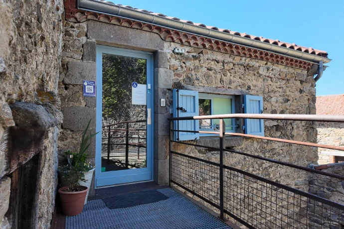 Entrée de la Maison Chaumet avec sa porte vitrée, sa rampe d’accès et ses murs en pierre.
